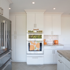 Tall pantry cabinets and wall ovens between the refrigerator and a corner counter