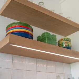 LED strip lighting set into the underside of a maple floating shelf