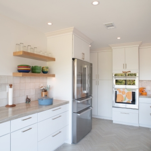 Maple floating shelves, refrigerator, and oven wall seen from the sink side